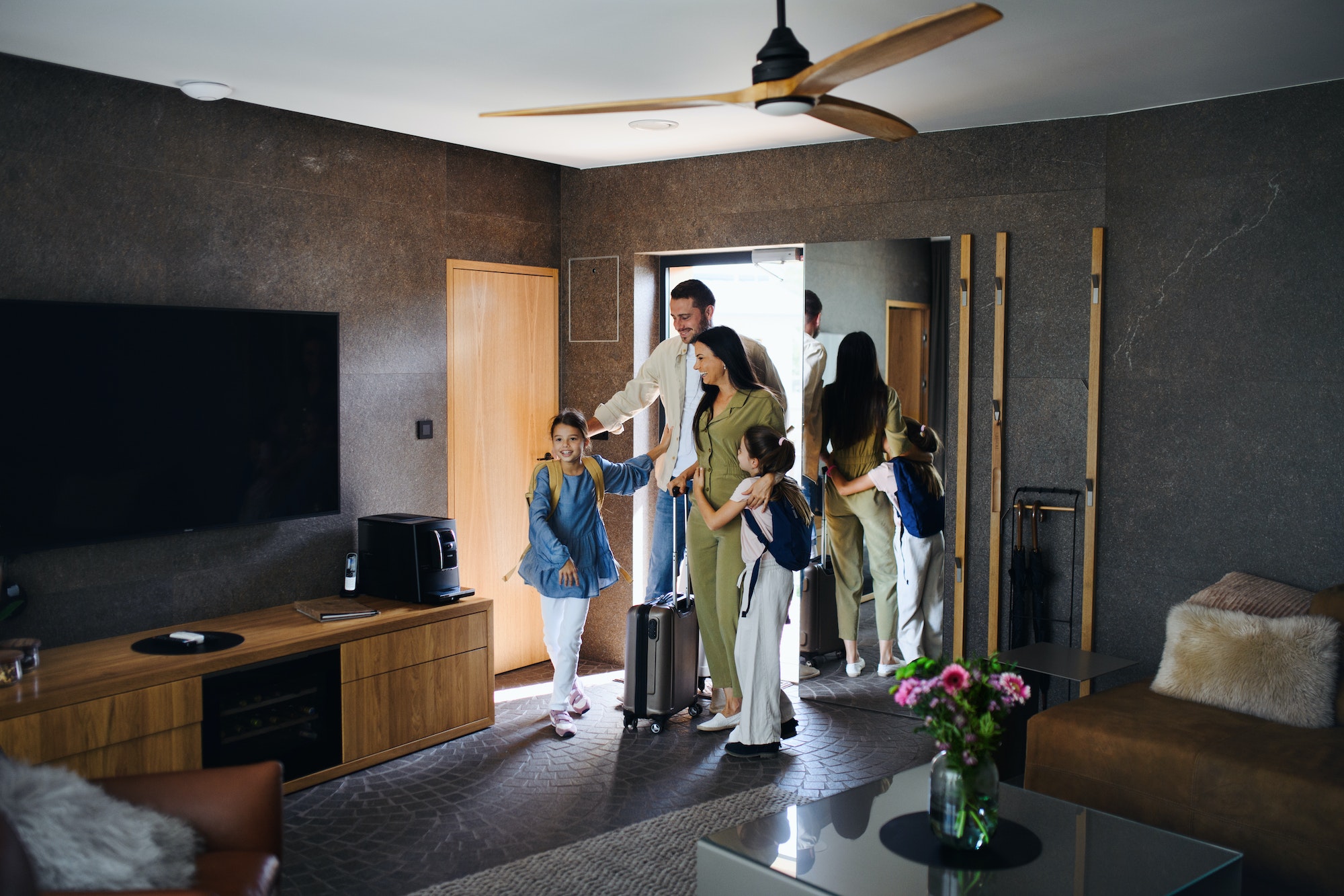 happy-young-family-with-two-children-enetring-room-at-luxury-hotel-summer-holiday.jpg